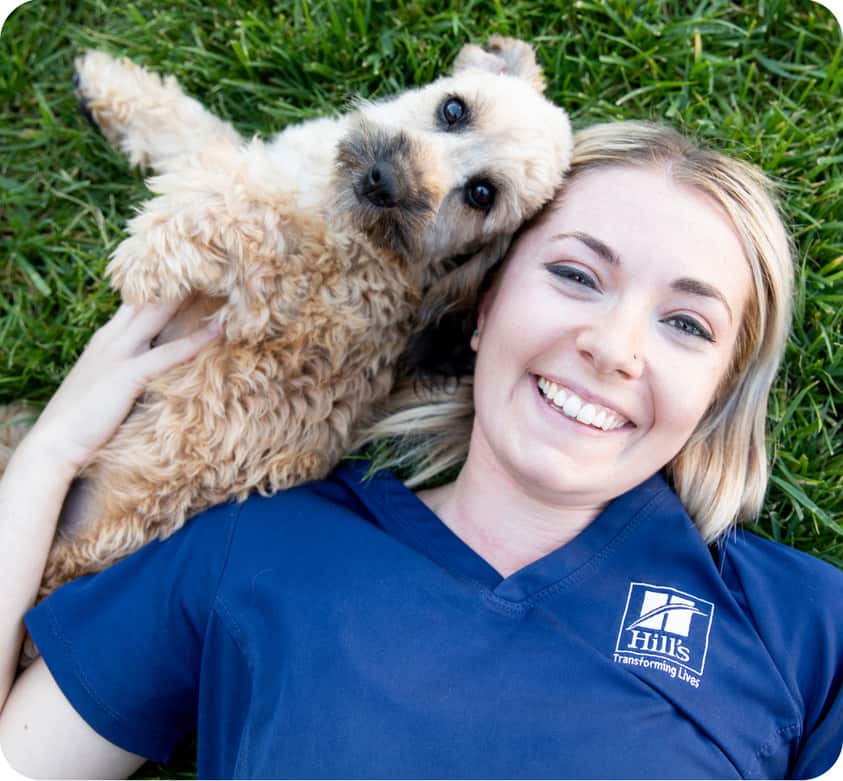 vet nurse on grass playing with a dog